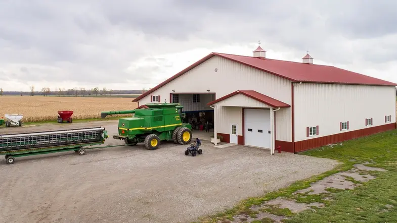 A farm building with agricultural machinery outside, of the kind monitored by Detectium