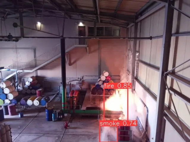 Fire and smoke detected inside an industrial building, each marked with a labelled box and confidence score